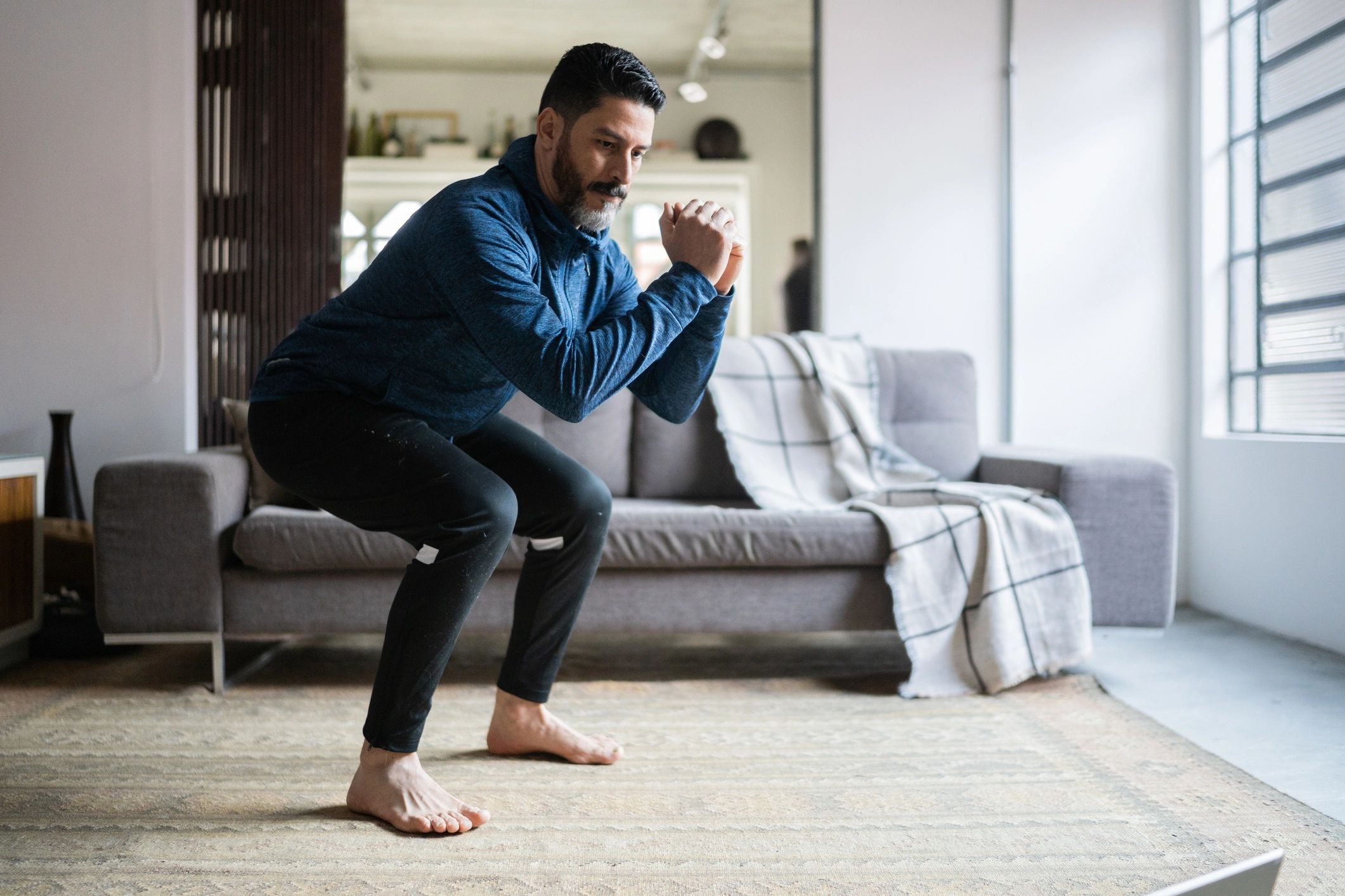 Man squatting at home