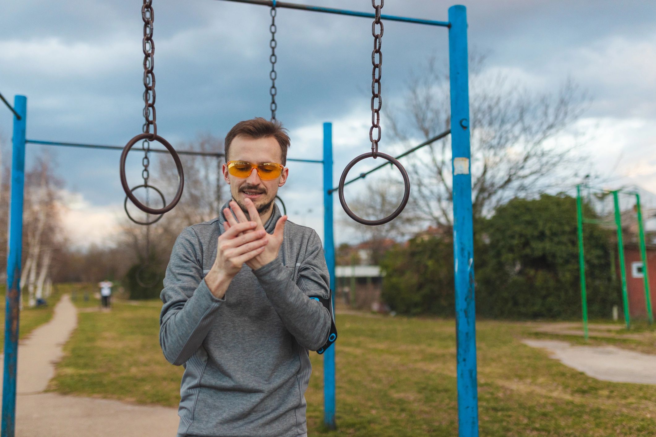 Athlete checking hands after gymnastics rings training outdoors