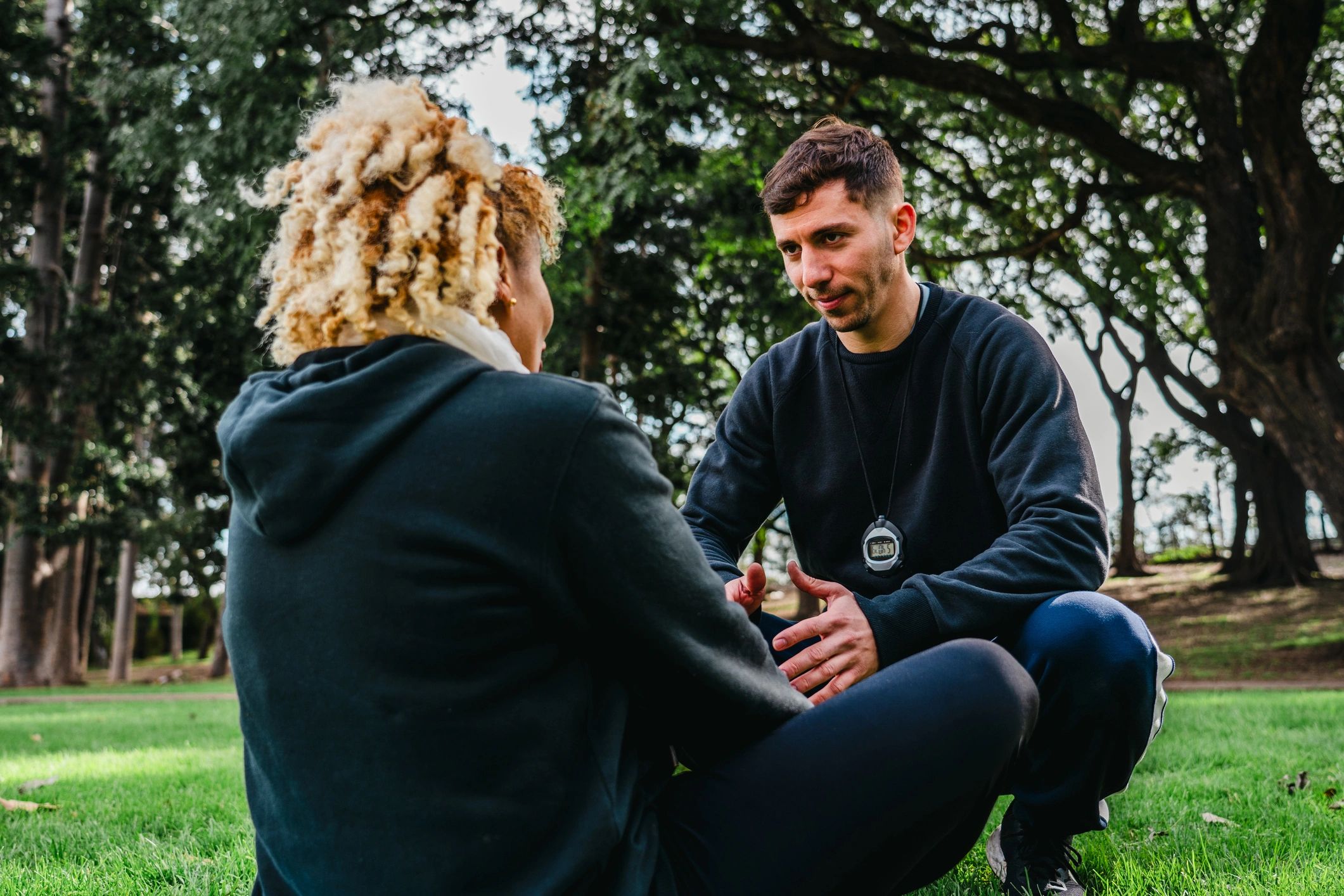 Coach speaking with client during outdoor training
