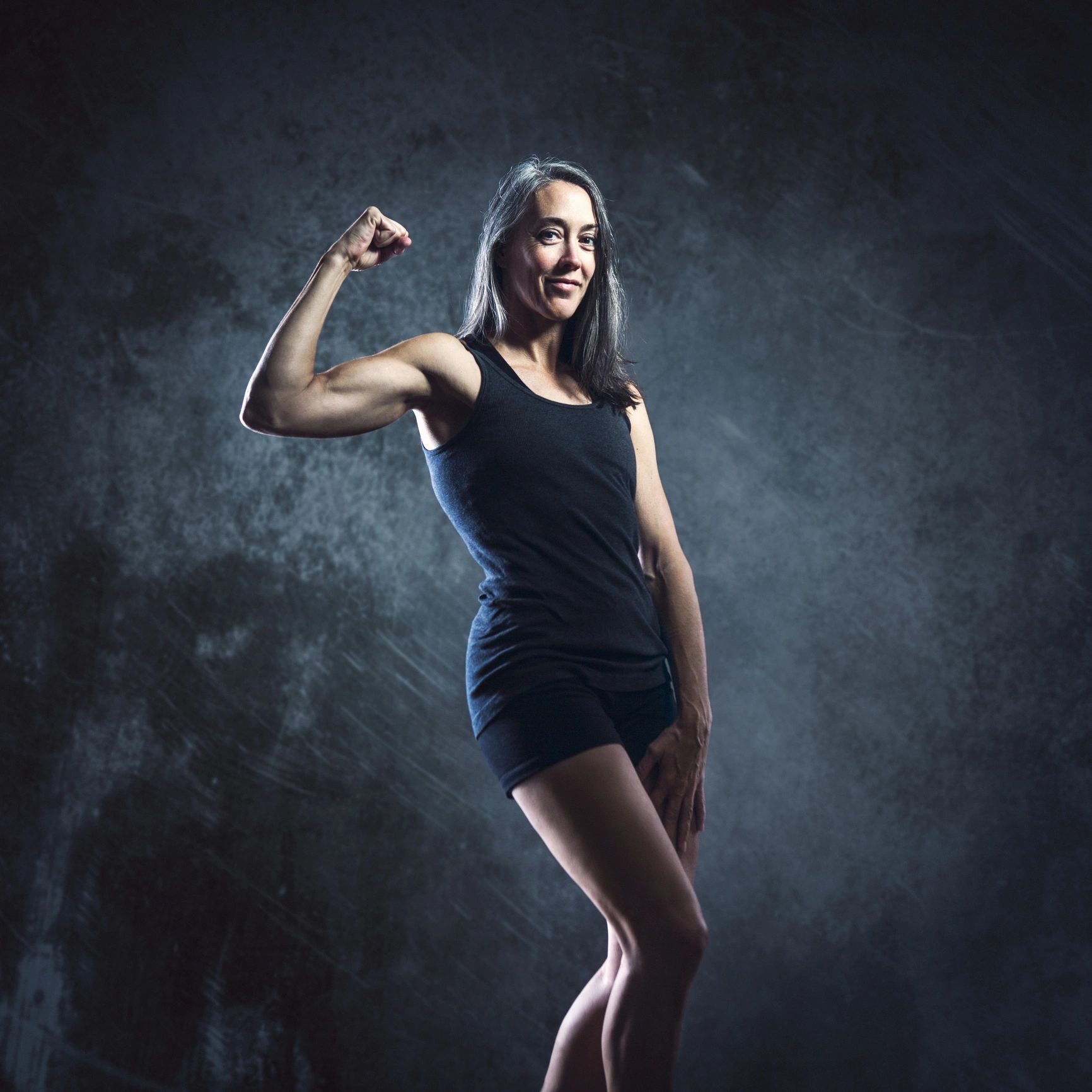 Portrait of a confident fitness client flexing bicep